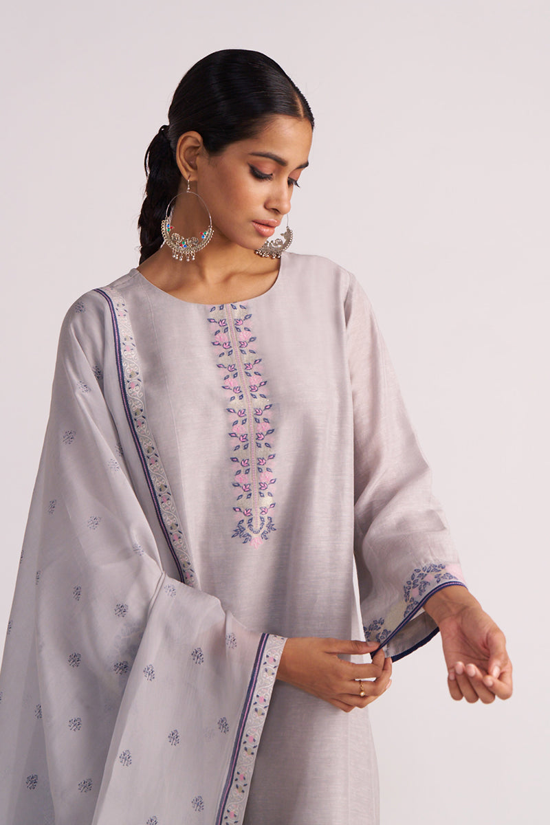 Woman wearing a Grey Woven Kurta Set with floral embroidery on a plain background