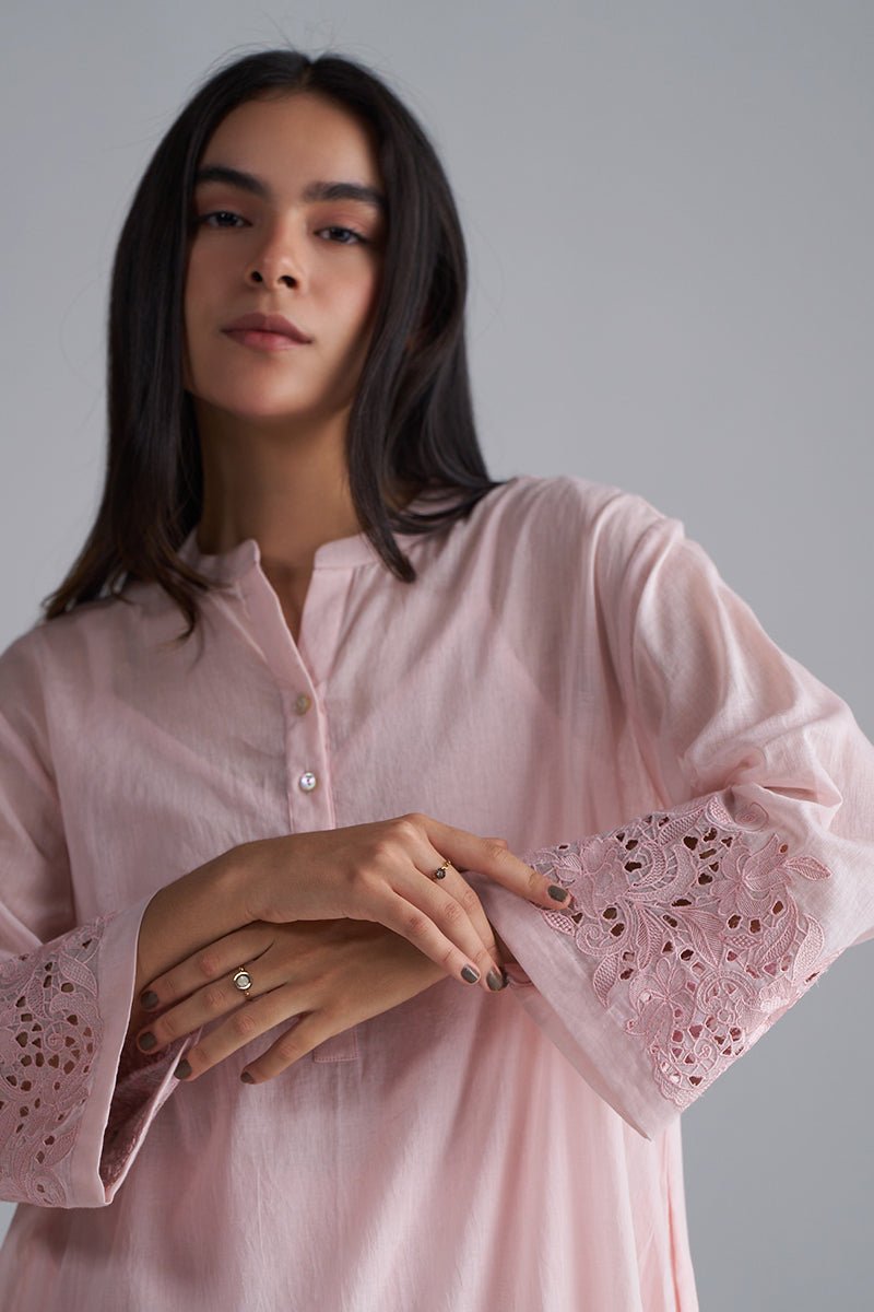 Woman wearing a pink blouse with lace sleeves against a gray , Crystal Pink Mul Mul Co-ord Set for Women | Ganga Fashionsbackground