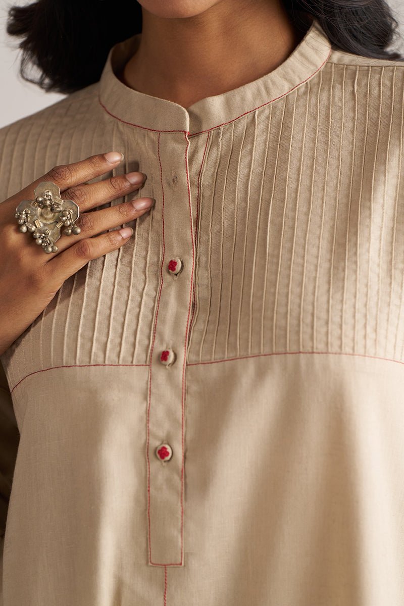 Close-up of a beige kurta with red buttons and stitching details. | Brown Rice Co-ord Set – Solid Ethnic Wear | Ganga Fashions