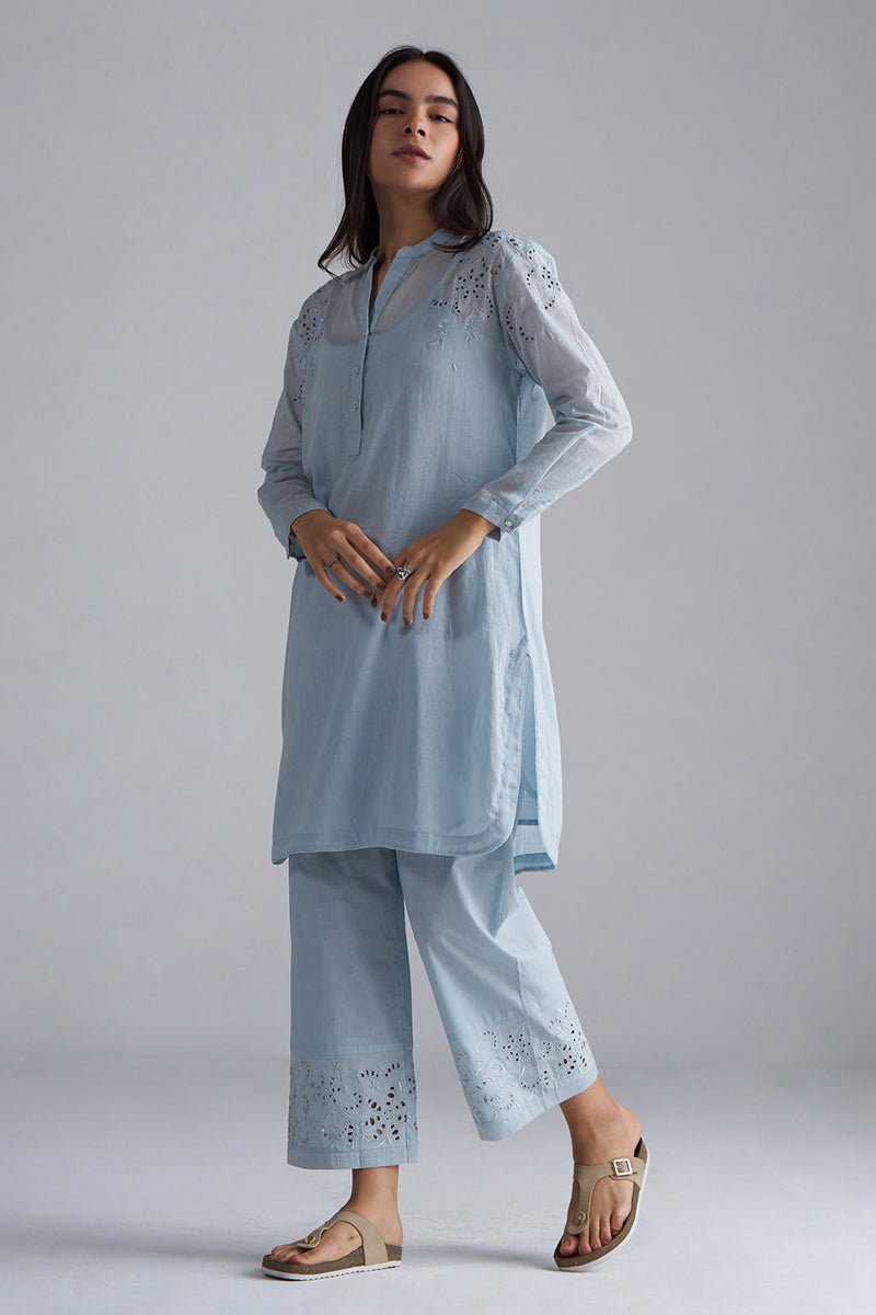 Woman wearing a light blue embroidered outfit on a gray background | Chalk Blue Mul Mul Co-ord Set for Women | Ganga Fashions