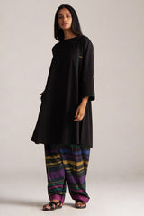 Woman wearing a black long-sleeve top and colorful striped pants on a plain background | Black Multi Colour Checkard Co Ord Set