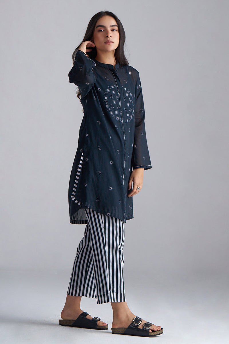 Woman wearing a dark blue patterned outfit with black and white striped pants on a gray background | Black & White Mul Mul Co-ord Set for Women | Ganga Fashions