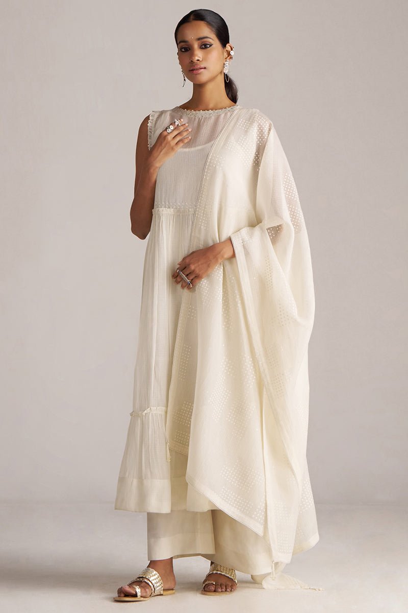 Woman wearing a cream-colored traditional outfit with a plain background | Ivory Kota Silk Kurta Set for Women