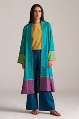 Woman wearing a teal and purple traditional outfit with a yellow top on a plain background | Navigate Blue Checkard Kimono with Moss Yellow Top and Blue Bottom Co Ord Set