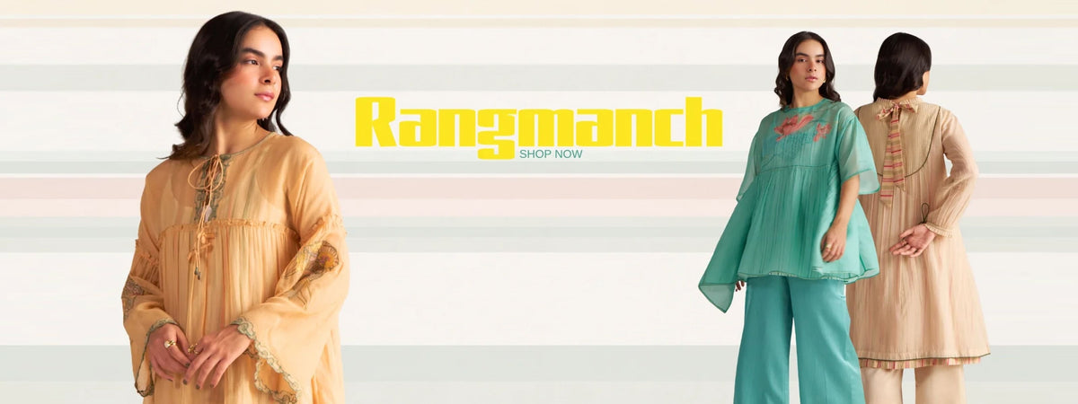 Three women modeling traditional South Asian salwar kameez sets in a studio setting with a light striped background and a yellow 'Rangmanch' logo overlay. The outfits include a beige tunic with gold embroidery on the left, a mint green set in the center, and a light peach set on the right. | rangmanch collection | modern ethnic wear | ganga fashions